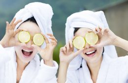 beautiful woman showing fresh lemon in spa